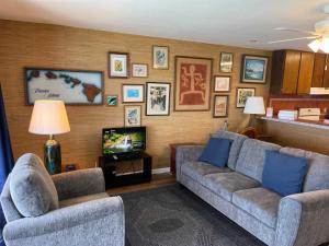a living room with two couches and a television at Oceanfront Vintage Retreat in Kailua-Kona in Kailua-Kona