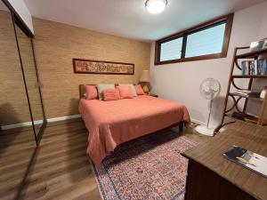 a bedroom with a bed with orange sheets and a window at Oceanfront Vintage Retreat in Kailua-Kona in Kailua-Kona