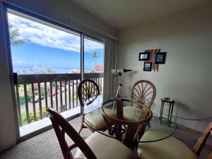 a dining room with a table and chairs and a large window at Kona Mansions - Ocean Views & Amenities in Kailua-Kona