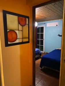 Una habitación con una cama y un cuadro en la pared. en La casita 2 Piso compartido, en Puerto Iguazú