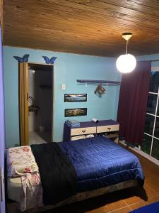 Un dormitorio con una cama y un escritorio y una ventana. en La casita 2 Piso compartido, en Puerto Iguazú