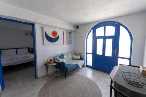 a room with a blue door and a bed and a chair at Phone Booth in Koutsounari