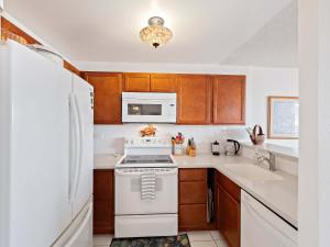 a kitchen with a white stove top oven next to a sink at Kolu Honu - Stunning Beachfront Condo for 2 in Kailua-Kona