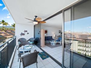 a room with a balcony with a table and chairs at Kolu Honu - Stunning Beachfront Condo for 2 in Kailua-Kona