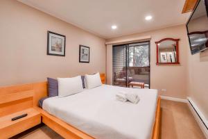 een slaapkamer met een groot wit bed met een raam bij Lakeland Getaway - Walk to Lake in South Lake Tahoe