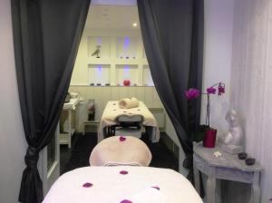 a spa room with two beds and a mirror at Hôtel Restaurant & Spa Plaisir in Le Bois-Plage-en-Ré