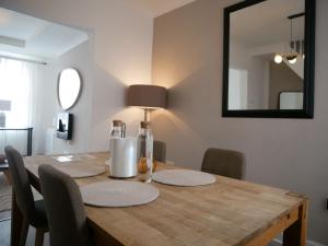 a dining room table with chairs and a mirror at Luxury Stay by Etihad Stadium in Manchester
