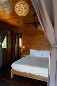 a bedroom with a bed in a wooden room at Hotel Solana Bacalar Lakefront in Bacalar