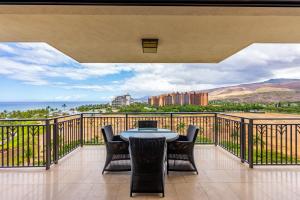 a patio with a table and chairs on a balcony at Panoramic Ocean Views in Ko Olina in Kapolei