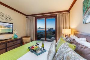a bedroom with a bed with a table and a television at Beachfront Condo in Ko Olina Paradise in Kapolei +22 photos
