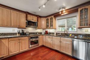 a kitchen with wooden cabinets and stainless steel appliances at Hall Court Manor - Hot tub Pet Friendly Pool Table in Stateline