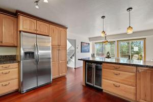 a kitchen with a stainless steel refrigerator and wooden cabinets at Hall Court Manor - Hot tub Pet Friendly Pool Table in Stateline +35 photos