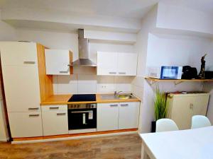 a kitchen with white cabinets and a stove top oven at Schwert City Loft S63 in Verden