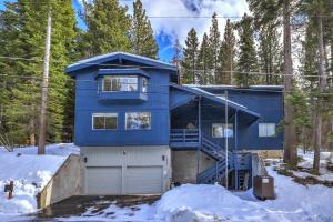 una casa azul con un garaje en la nieve en Southern Pines Arcade Games & Foosball for Kids, en South Lake Tahoe