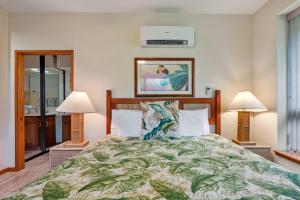 a bedroom with a large bed with two lamps at Romantic Studio in Waikoloa Beach Resort in Waikoloa