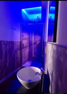a bathroom with a white sink and a blue light at Loft 23 in Empoli +13 photos
