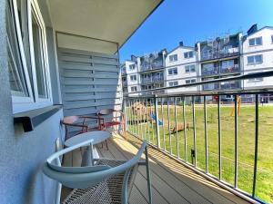 a balcony with two chairs and a dog on a playground at Dębina Spot 27 in Debina