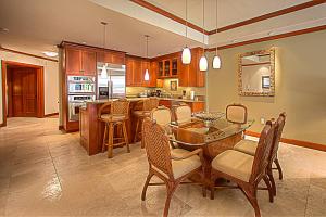 a large kitchen with a table and chairs and a counter at Kolea 11D - Walk to the Beach in Waikoloa
