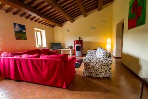 sala de estar con sofá rojo y mesa en Casale Coccinella, en Preci
