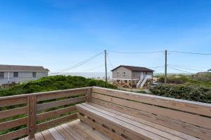 a wooden bench on a deck with a house in the background at 7145 - Geri's Place #6 Flip Flop in Wanchese