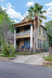 een palmboom voor een huis met een hek bij King William - A Birdy Vacation Rental in San Antonio
