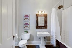 een badkamer met een toilet, een wastafel en een spiegel bij King William - A Birdy Vacation Rental in San Antonio +40 foto's