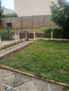 a backyard with a yard with grass and a fence at La studette in Saint-Michel-sur-Orge