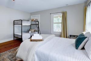 een witte slaapkamer met 2 stapelbedden en een raam bij King William - A Birdy Vacation Rental in San Antonio