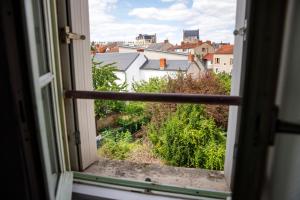 an open window with a view of a city at La Place Servant 2 in Montluçon