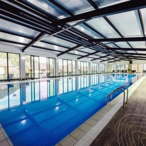 a large swimming pool with blue water at Bakuriani Crystal Loft Apt in Bakuriani