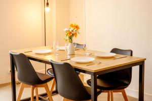 a wooden table with chairs and a vase of flowers at La Place Servant 2 in Montluçon