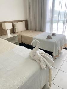 une chambre d'hôtel avec deux lits avec des serviettes dessus dans l'établissement The Experience Iloa Residenci, à Barra de São Miguel