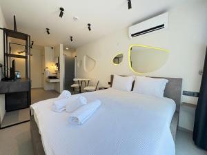 a bedroom with a large white bed with towels on it at Arıcan suite in Eskiömerler