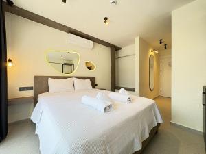 a bedroom with a white bed with two towels on it at Arıcan suite in Eskiömerler