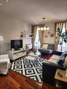 Una sala de estar con un sofá y un televisor. en Elduayen Luxury Centro, en Vigo