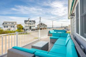 a balcony with a blue couch and chairs on a building at 2-Min Walk to Beach Large Deck with Outdoor Sofas in Wells