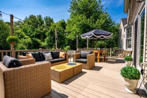 a patio with couches and an umbrella on a deck at Maine Adventure 3BR Oasis Awaits in York