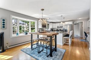 a kitchen with a island with bar stools at Maine Adventure 3BR Oasis Awaits in York +33 photos
