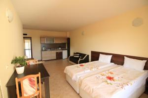 a bedroom with a large bed and a kitchen at Hotel Marant in Sozopol