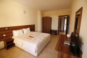 a bedroom with a bed and a table and a television at Hotel Marant in Sozopol