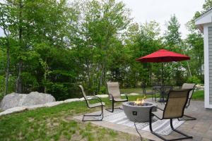 a patio with a table and chairs and an umbrella at Maritime Meadows - Charming Resort-Style Home in Arundel