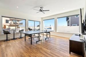 a living room with a table and chairs and windows at Oceanfront Home Beach Access Deck & Ping Pong in Old Orchard Beach
