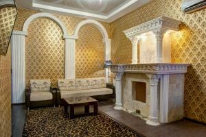 a room with a fireplace with a bench and a table at Frant Hotel in Volgograd