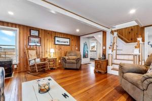 ein Wohnzimmer mit Holzwänden und Holzböden in der Unterkunft Oceanfront - Front Porch - Back Deck - Kitchen in Wells