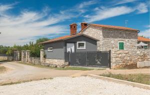 a stone house with a gate on a road at Stunning Home In Umag With Wifi in Umag