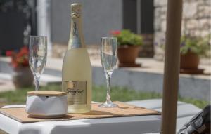 a bottle of wine and two glasses on a table at Stunning Home In Umag With Wifi in Umag +16 photos