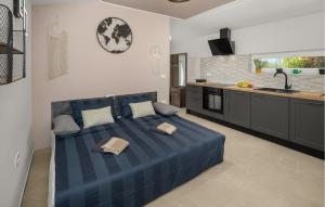 a bedroom with a blue bed and a kitchen at Stunning Home In Umag With Wifi in Umag
