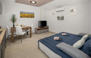 a bedroom with a bed and a table and a kitchen at Stunning Home In Umag With Wifi in Umag