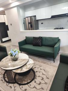 a living room with a green couch and a table at Spacious 1Br in Westlands in Nairobi
