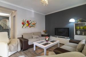 a living room with a couch and a tv at Encantadora Casa De Dos Plantas En Pleno Centro in Águilas
